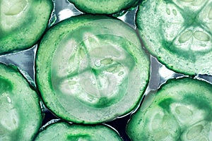 Details of green sliced cucumbers on a glowing background, close up