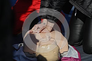 Details with the hands of an emergency medical services worker performing cardiopulmonary resuscitation CPR on a mannequin for