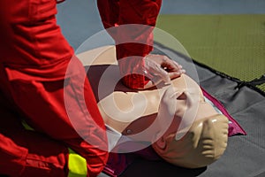 Details with the hands of an emergency medical services worker performing cardiopulmonary resuscitation CPR on a mannequin for