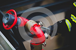 Details with the hands of a firefighter holding a fire suppression system hydrant on a hospital helipad