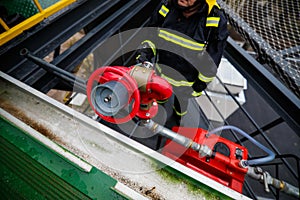 Details with the hands of a firefighter holding a fire suppression system hydrant on a hospital helipad