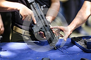 .Details with the hands of a man holding an automatic rifle