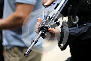 .Details with the hands of a man holding an automatic rifle
