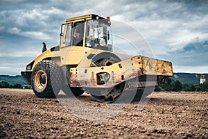 Details of highway construction site - industrial machinery, vibratory soil compactor working
