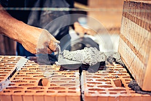 Details of industrial bricklayer installing bricks on construction site