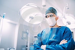 Details of man, surgeon specialist wearing goggles and scrubs ready for surgery