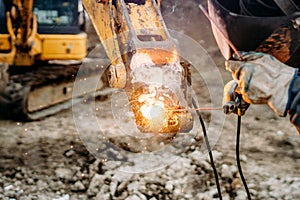 Details of mechanic, worker welding excavator