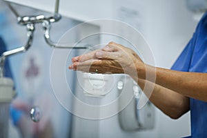 Details with a medic washing her hands before a medical procedure