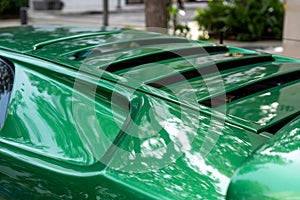 Details of new bright lamborghini design parked outside. Grass green sport car with thoughtful structure of back surface