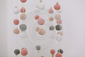 Details of newborn baby room. Toys above the baby crib. Hanging carousel of soft colorful balls for the child.