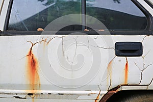 Details of old peeling paint and rusted white car