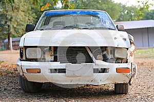 Details of an old rusted crash white car, Front view