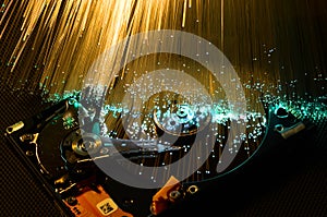 Details of opened computer hard disk drive with colored optic fiber effects