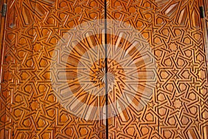 Details of an ornate carved cedar door at the Madrasa Bou Inania in Fez, Morocco