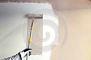 Details of painting walls, industrial worker using roller and other tools for painting walls