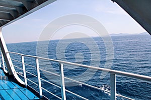 Details of passenger boat. Cruise ship deck. Picturesque view from ship deck on navy blue sea, horizon and sky during vacation.