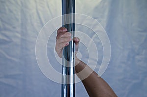 Details of pole dancer`s hands holding the pole. Concept sport, dance, health photo