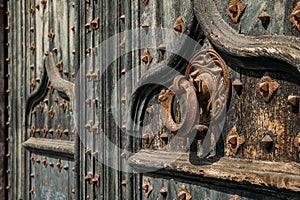 Details of portal to Cathedral. Metal knocker on wrought iron reinforced old wooden doors to Girona Cathedral, Spain