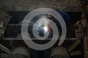 Details with a professional welder welding an industrial metallic pipeline photo