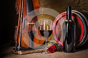 Red wine in glass, barell and violin
