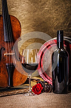 Red wine in glass, barell and violin