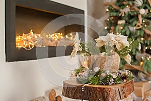 Details Rustic living room for Christmas. Fireplace and decor of fir branches and Rustic flowers for New Year close-up and copy sp