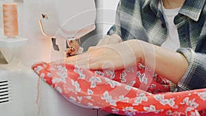 Details of sewing machine. Close up of woman`s hands working on overlock. Female designer sew on sewing machine. Fashion and creat