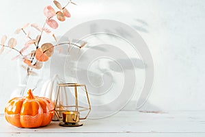 Details of Still life, cup of tea or coffee, pumpkins, candle, brunch with leaves on white table background, home decor