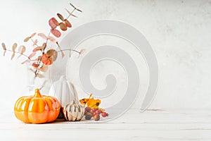 Details of Still life, cup of tea or coffee, pumpkins, candle, brunch with leaves on white table background, home decor