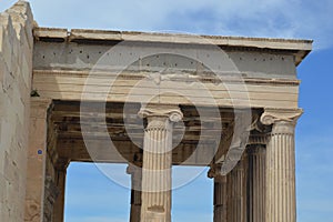 Details of the Temple of Athena Nike under a blue cloudy sky in Athens, Greece.