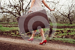 Details of woman holding retro suitcase