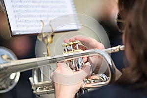 Details of woman's hands playing the trumpet