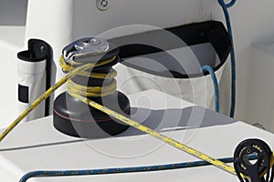 Details of yellow genoa sheet secured on self-tailing winch on sailing boat racer, boating concept