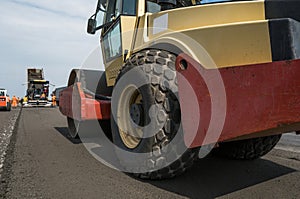 Details of yellow red Heavy Vibration roller compactor at asphalt pavement works for road repairing. Working on the new