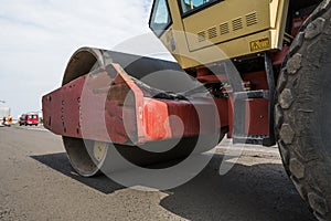 Details of yellow red Heavy Vibration roller compactor at asphalt pavement works for road repairing. Working on the new