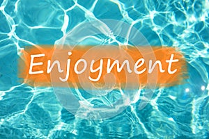 Detal of word `Enjoyment` on swimming pool water and sun reflecting on the surface photo