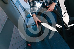 detalle frontal de una mujer joven limpiando el coche con una aspiradora. photo