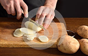 Detallle of a chef slicing potatoes