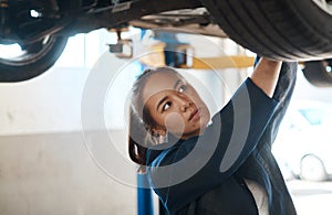 Detecting problems and doing repairs is what I do. a female mechanic working under a lifted car.