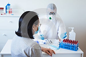 Detection of coronavirus concept. Doctor examines patient suspected coronavirus infection wearing protective equipment photo