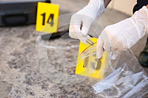 Detective collecting evidences at crime scene, closeup photo
