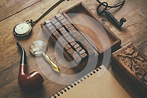 Detective concept. Private Detective tools: magnifier glass, old keys, smoking pipe, notebook. top view. vintage filtered image