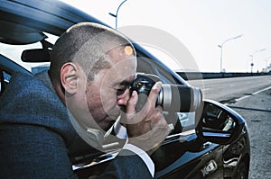 Detective or paparazzi taking photos from a car
