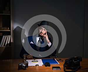 Detective sitting in dark room in vintage concept