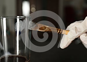 Detective taking fingerprints with brush from glass, closeup