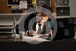 Detective working at desk in his office, processing evidence