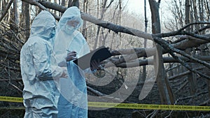 Detectives are collecting evidence in a crime scene. Forensic specialists are making expertise. Police investigation in