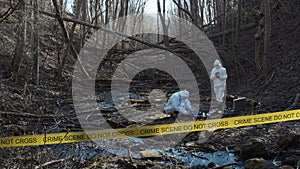 Detectives are collecting evidence in a crime scene. Forensic specialists are making expertise. Police investigation in