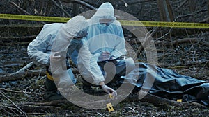 Detectives are collecting evidence in a crime scene. Forensic specialists are making expertise. Police investigation in