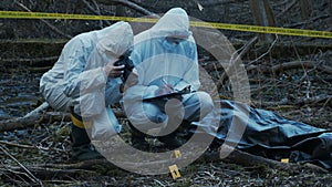 Detectives are collecting evidence in a crime scene. Forensic specialists are making expertise. Police investigation in